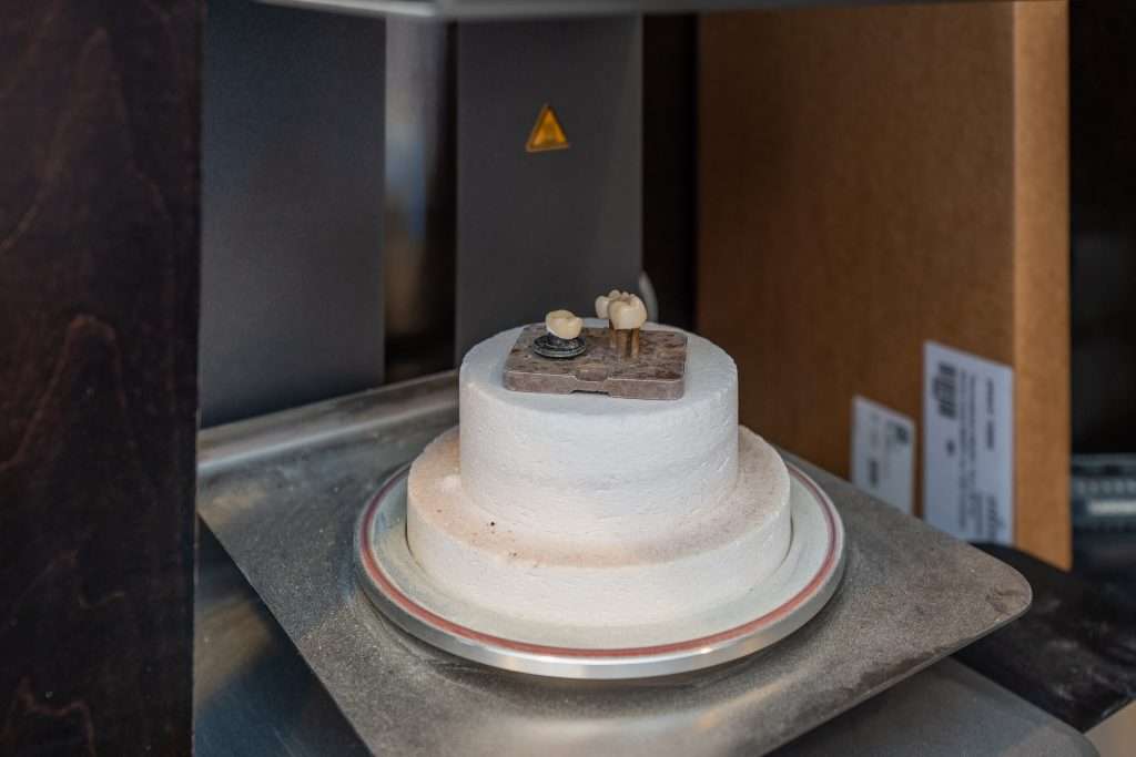 In-office CEREC crown milling machine producing a same-day ceramic crown at Sacramento Dentistry Group