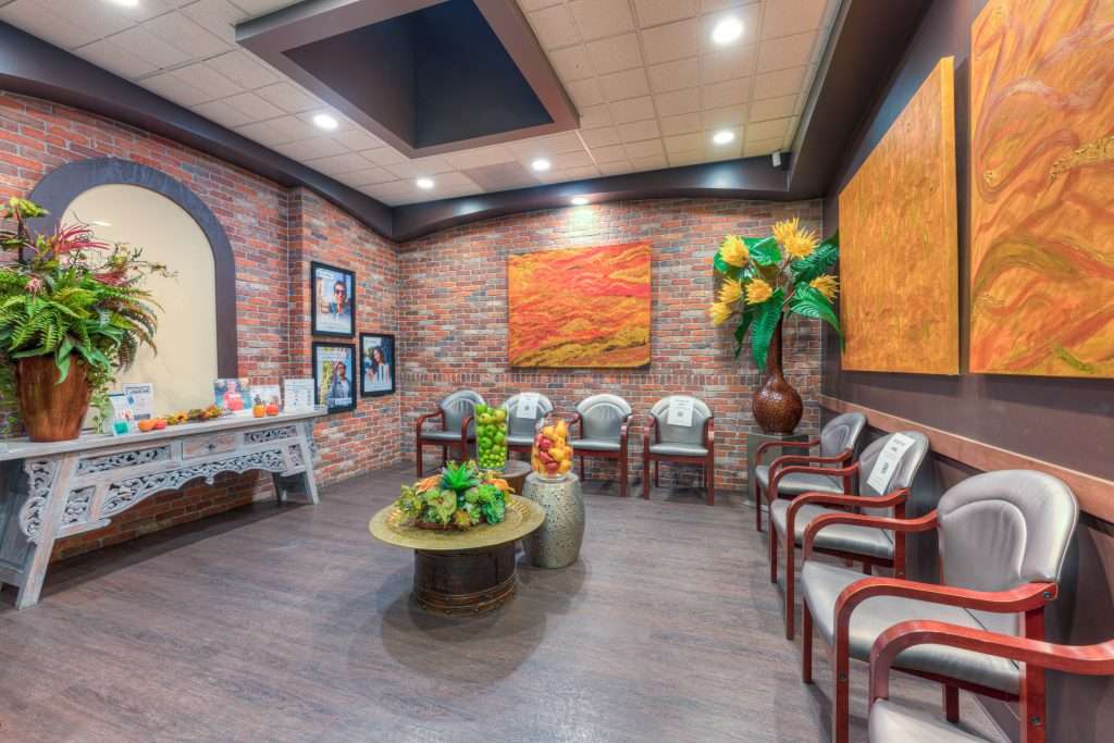 Sacramento Dentistry Group waiting room with contemporary artwork, exposed brick, and comfortable lounge seating