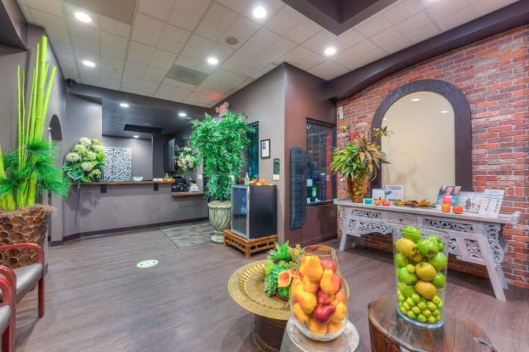 The Sacramento Dentistry Group lobby with exposed brick, warm lighting, live plants, and contemporary reception seating